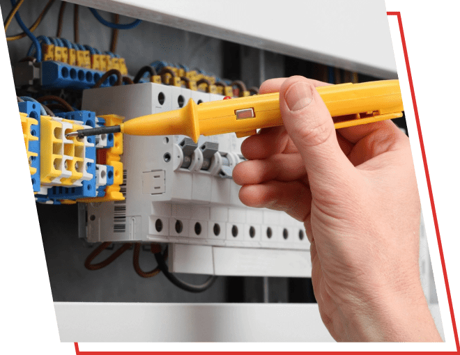 A person holding a yellow testing tool in front of an electrical box.