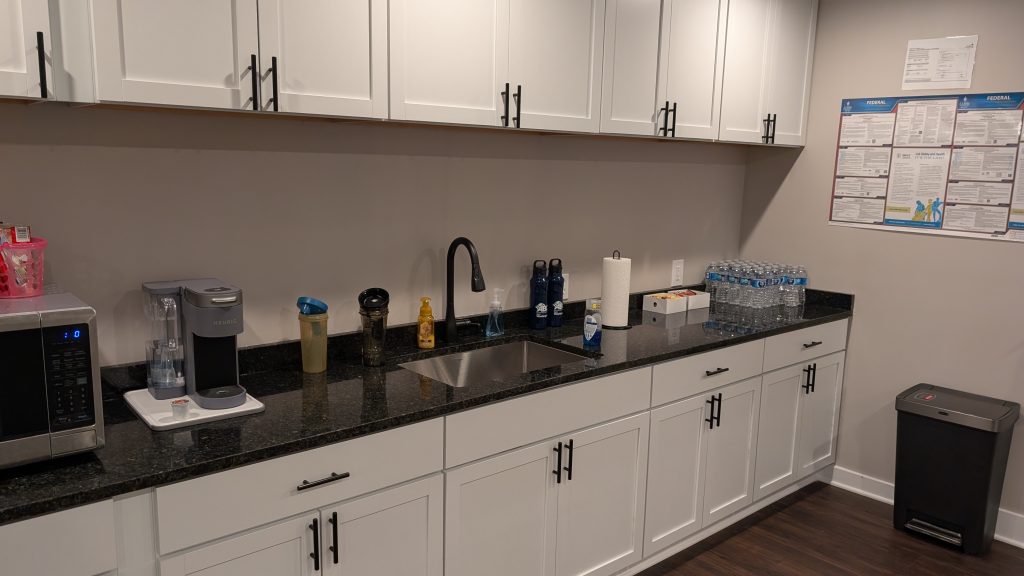 Office kitchen counter with appliances and supplies.